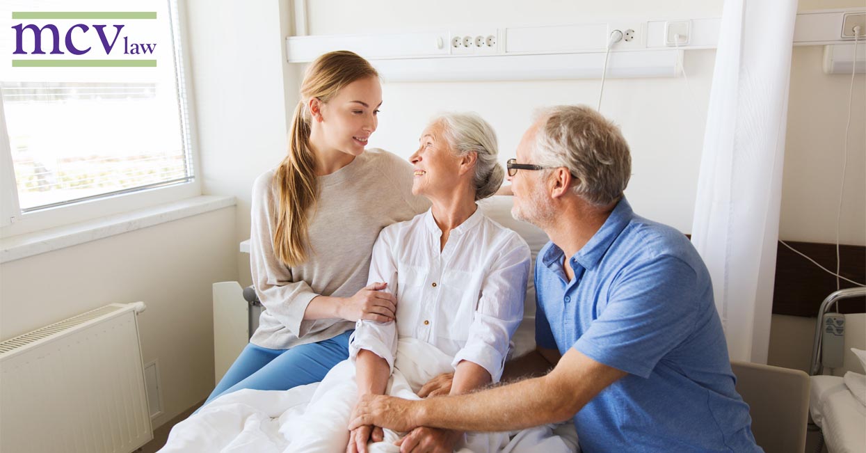 An adult daughter visits her mother in the hospital alongside her father