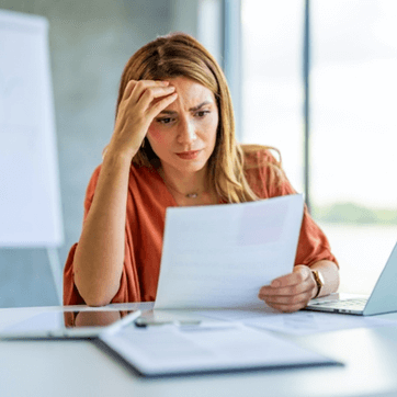 workers compensation lawyers near oneida ny image of woman looking frustrated and confused by paperwork