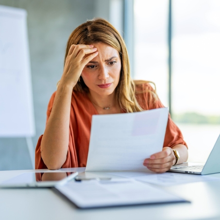 workers compensation lawyers near elmira ny woman looking at papers stressed