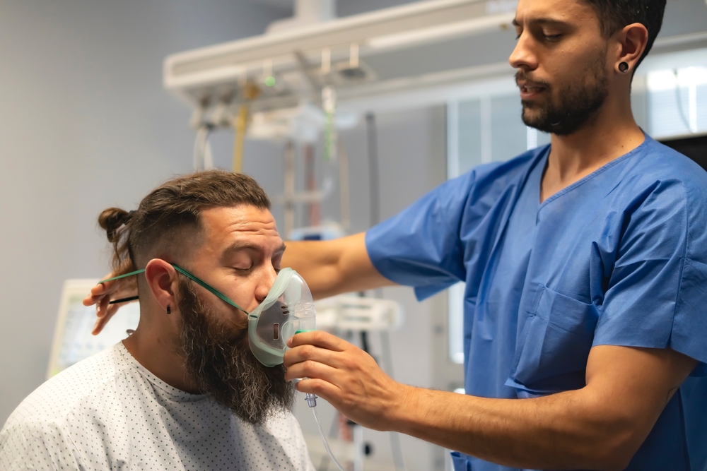 Nurse administering breathing treatment for long-term injury