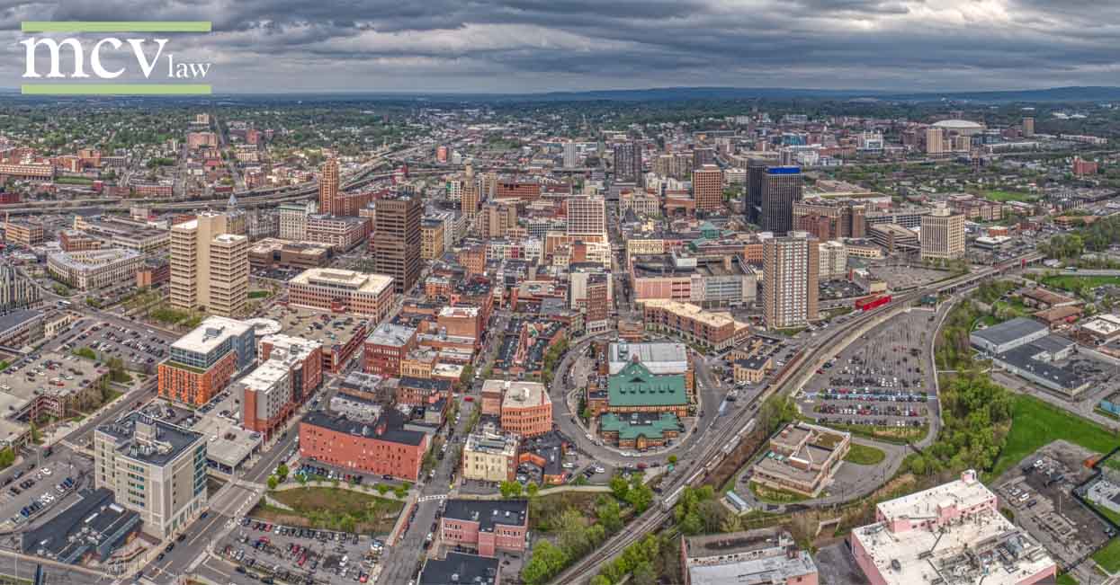 MCV Law logo over an aerial shot of the City of Syracuse