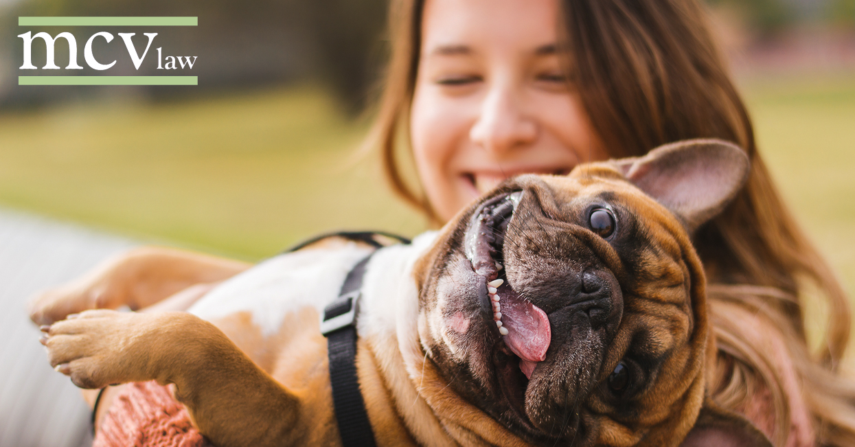 A woman holding her happy dog