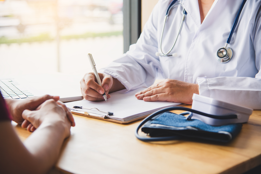 Doctor files insurance paperwork with patient