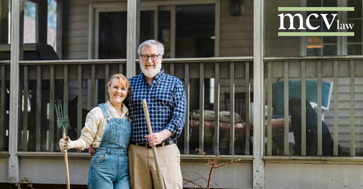 An older couple standing in front of their home
