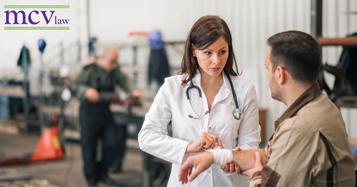 A doctor bandaging an injured workers wrist