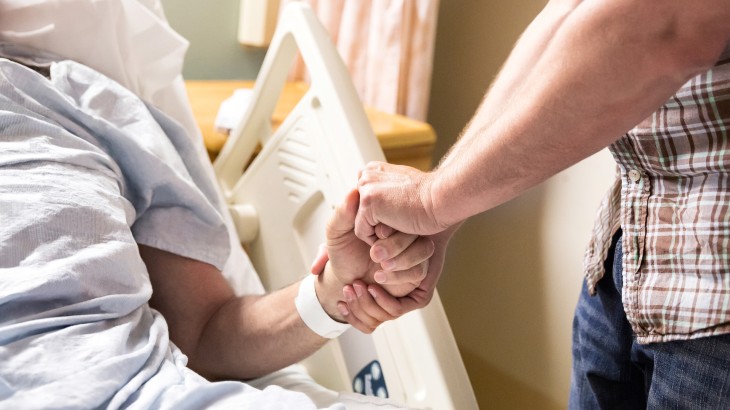 healthcare proxy wills and probates near syracuse ny and watertown ny image of man holding hands with sick man in hospital bed