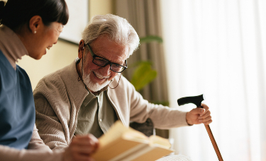 estate lawyers near syracuse ny for healthcare proxy elderly man with cane smiling while reading book with nurse