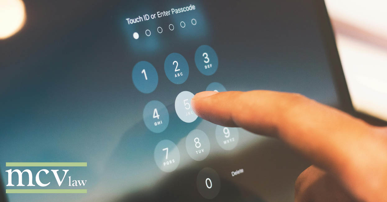 A person entering a password on a touch screen to access their digital vault